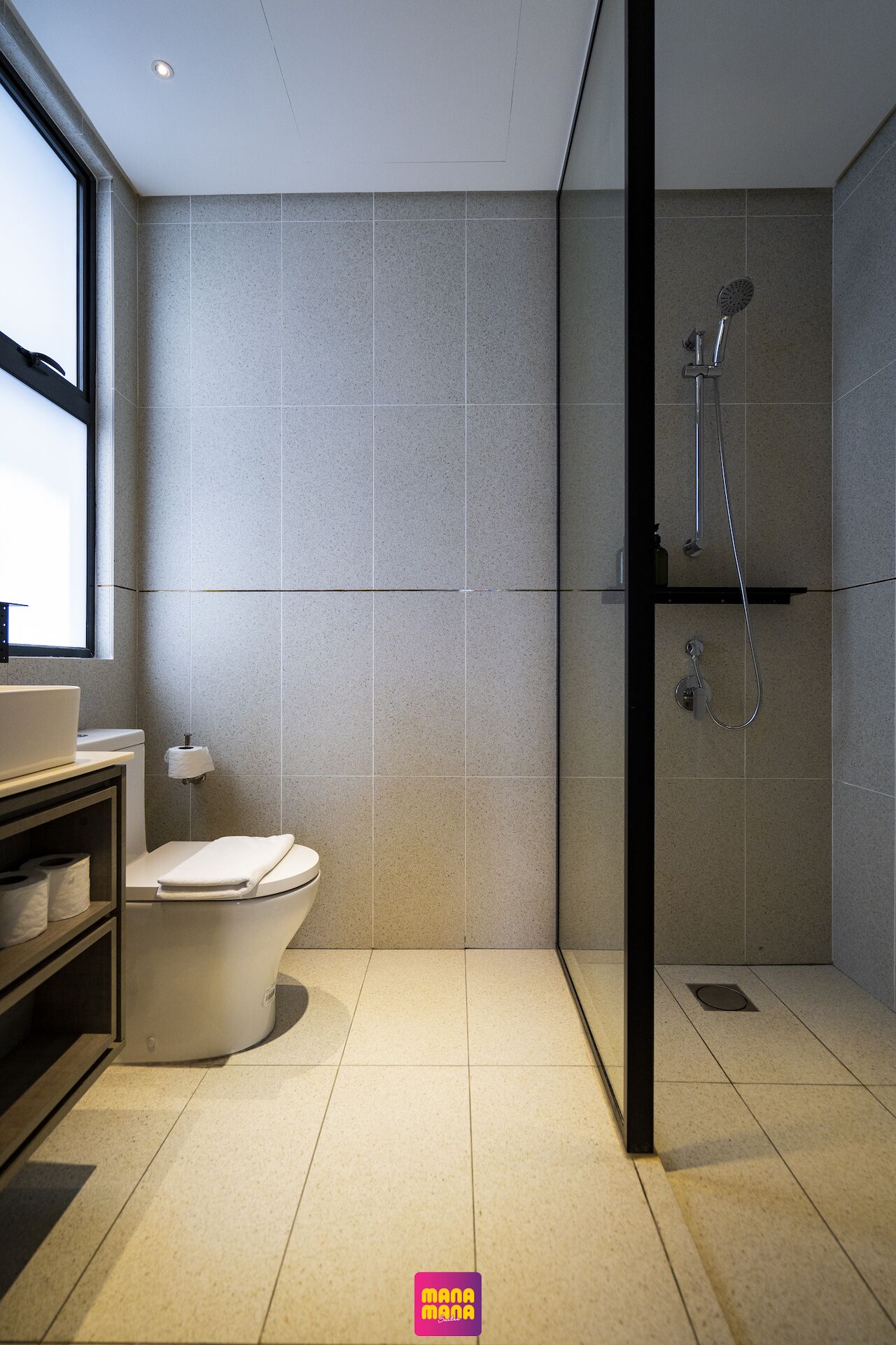 A modern bathroom with a toilet, sink, and shower.
