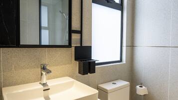 A modern bathroom with a large sink, toilet, and a mirror above the sink.