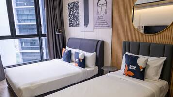 A hotel room with two beds, a ceiling fan, a large window, and a mirror on the wall.