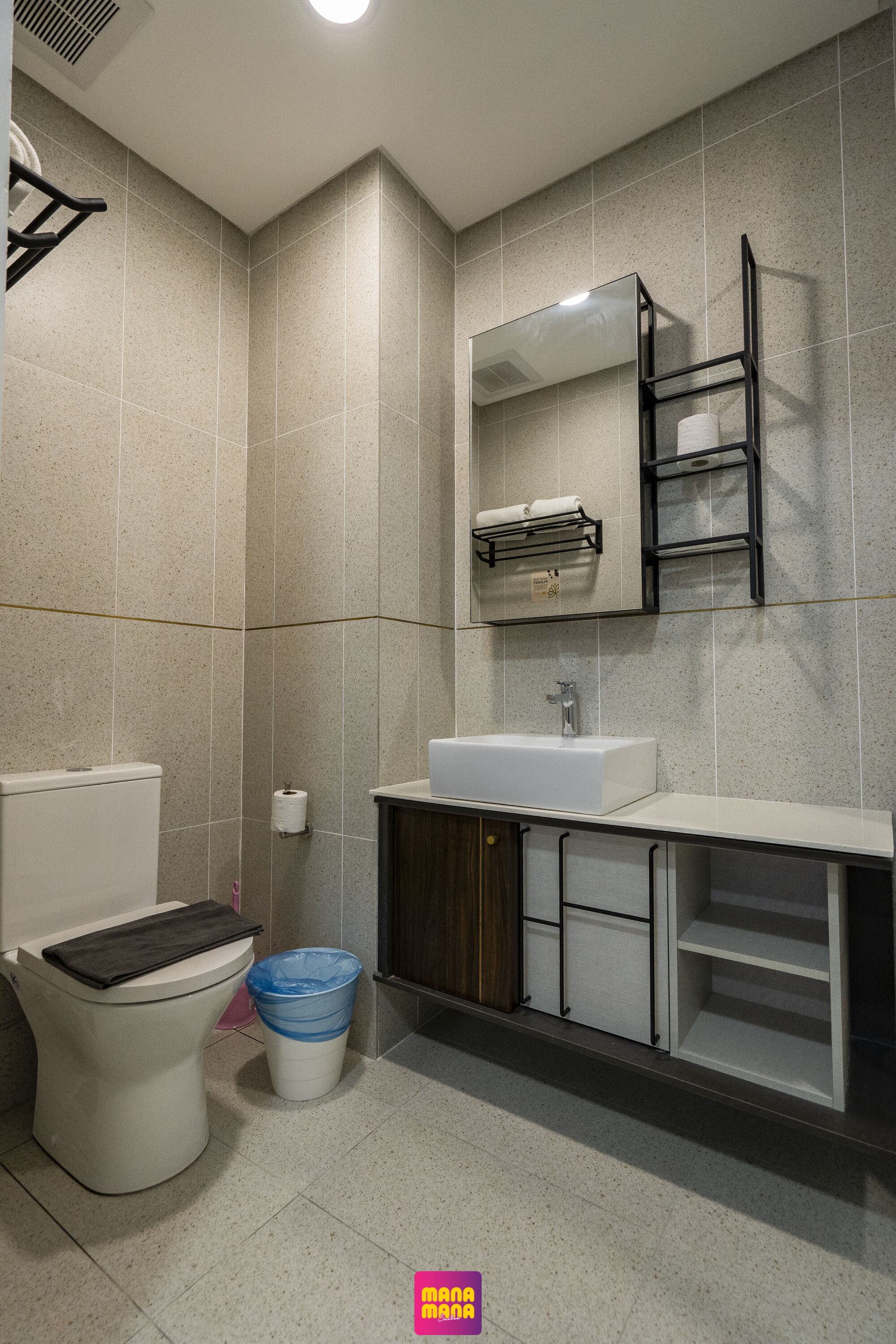 A modern bathroom with a toilet, sink, and mirror.