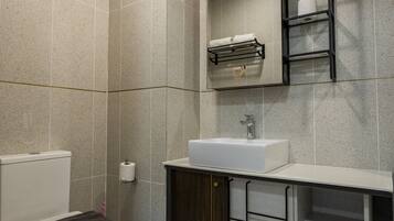 A modern bathroom with a toilet, sink, and mirror.