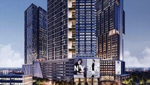 Un immeuble moderne de grande hauteur, doté de nombreux étages, de grandes fenêtres et d’une publicité bien visible au niveau inférieur.