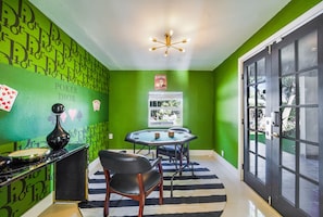 A room with green walls, a poker table, a chandelier, and a door with glass panels. - Dior Gorgeous Waterfront Villa, Infinity Pool & Hot Tub, Poker & Cinema rooms (Miami Gardens)