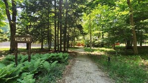 A sign labeled "WILLIAMS WAY" in a forested area with a gravel path.