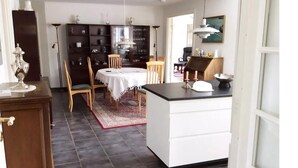 A dining area with a round table, chairs, a cabinet, and a kitchen counter. - Relaxing holiday in quiet surroundings (Frederikshavn)