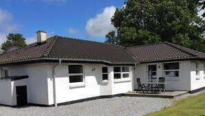 A single-story building with a tiled roof, a gravel driveway, and a grassy area. - Relaxing holiday in quiet surroundings (Frederikshavn)