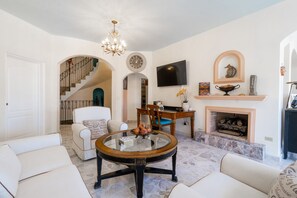 Een smart-tv, een open haard, boeken en een stereo