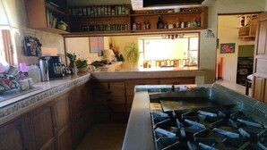 A kitchen with a central island, wooden cabinets, and a variety of kitchen appliances.