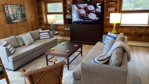 A cozy living room with two sofas, a coffee table, and a television.