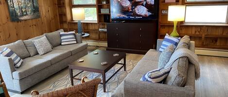 Un salon confortable avec deux canapés, une table basse et un téléviseur.