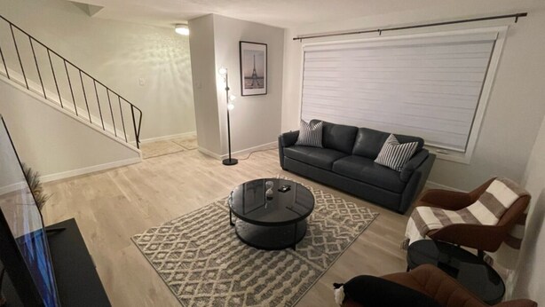 A living room with a sofa, armchairs, a coffee table, and a staircase. - Beautiful and Spacious 3 BDR/3 Beds Home (Winnipeg)