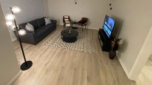 A living room with a sofa, coffee table, TV, and decorative items. - Beautiful and Spacious 3 BDR/3 Beds Home (Winnipeg)