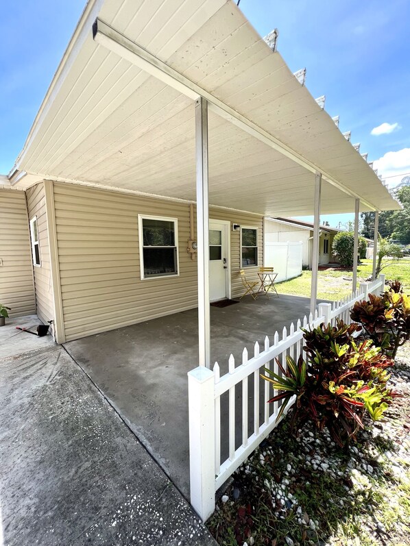 A single-story house with a covered porch and a white picket fence.