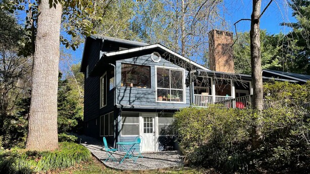 A two-story house with a balcony, surrounded by trees and a garden. - Private Apartment on Beautiful Grounds, Walking Distance to Landrum SC (Landrum)
