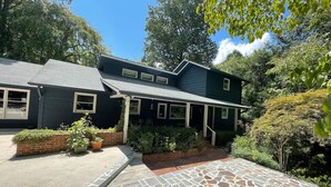 A two-story house with a stone-paved driveway and a brick border. - Private Apartment on Beautiful Grounds, Walking Distance to Landrum SC (Landrum)