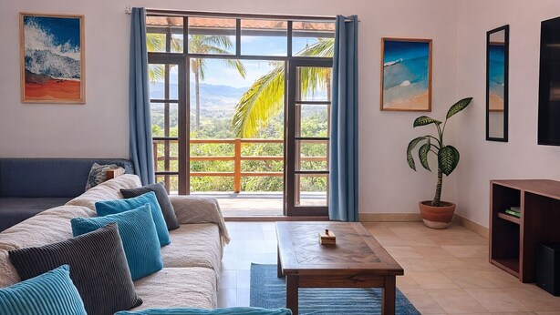A living room with a sofa, a coffee table, and a potted plant. - New listing, Open air apartment,  pool, balcony & jungle view. 5 mins to beach (Sayulita)