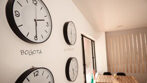 A wall with four clocks, a wooden table, and chairs. - Primitivo Usaquén dn (Bogotá)
