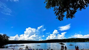 A beach with people, boats, and umbrellas.