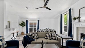 A modern living room with a sofa, coffee table, and a fireplace. - Hidden Gem in Fort Worth with Hot Tub & Mini Golf (Watauga)