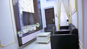 Un salon moderne avec un téléviseur à écran plat, un canapé et une table basse.