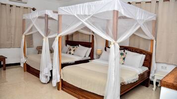 A double bed with a canopy, a bedside table, and a lamp.