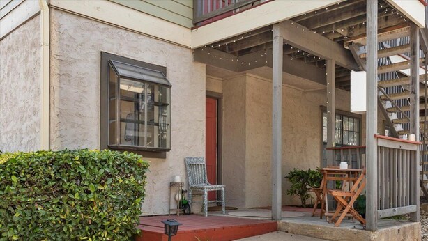 A building with a covered porch, a window, and a staircase. - SoCo Condo, 2br/2ba, updated bright space with great pool + parking! (Austin)