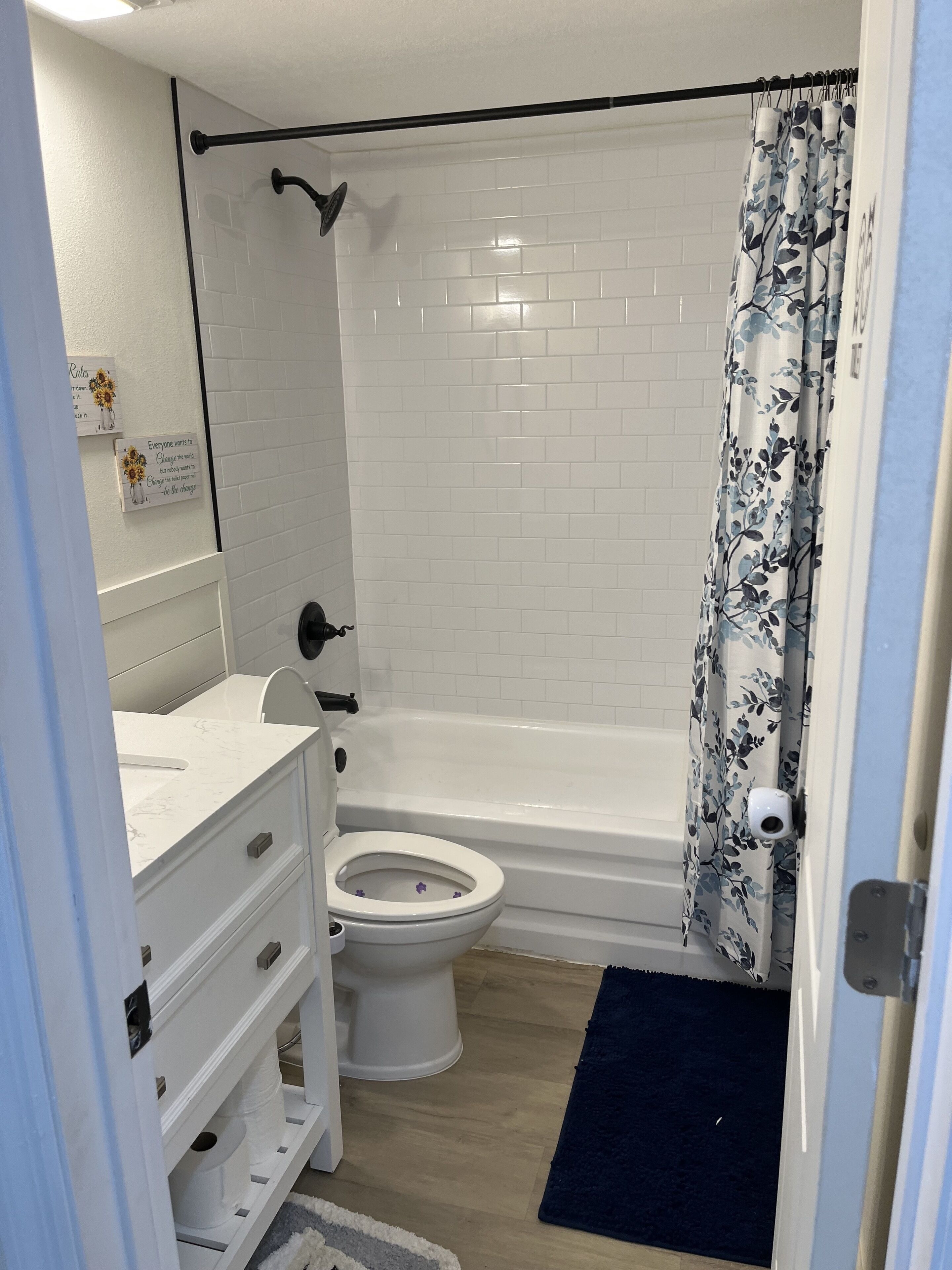 Un baño con inodoro blanco, bañera y cortina de ducha.