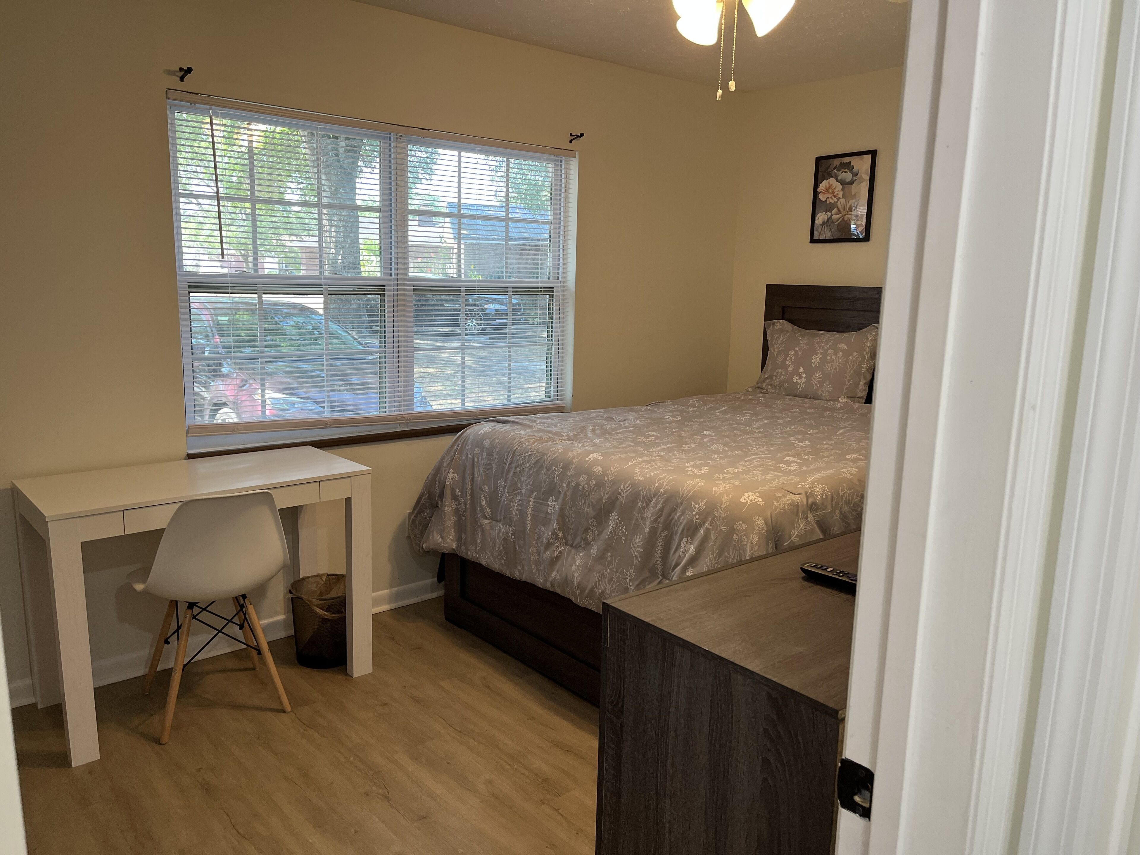 Un dormitorio con cama, escritorio y silla.