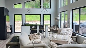 A spacious living room with a large window, a fireplace, and a dining area.
