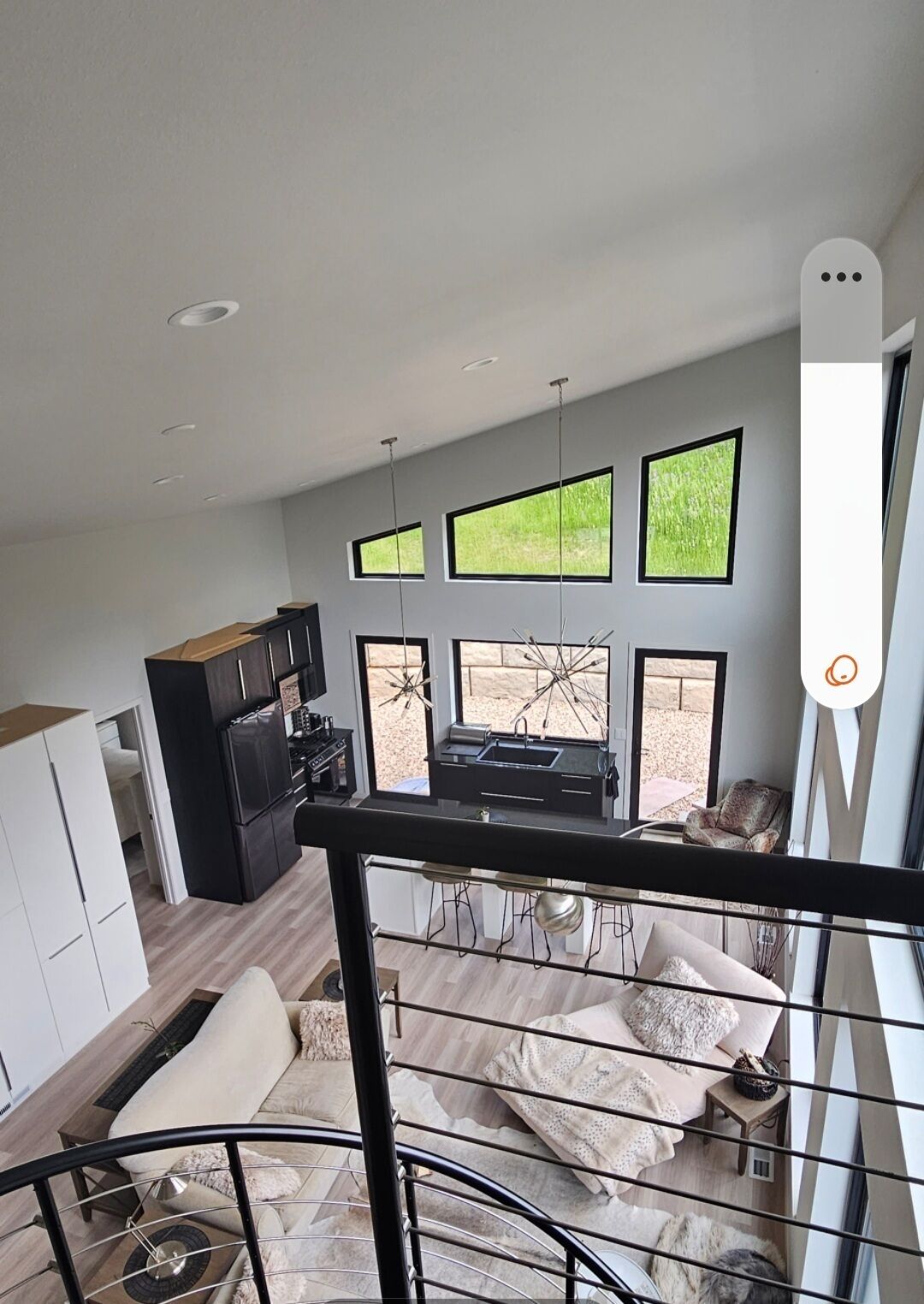 Ein moderner Wohnraum mit Küche, Essbereich und einem Balkon mit großen Fenstern.