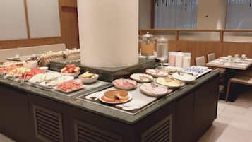 En buffet med forskellige retter og et siddeområde med borde og stole.