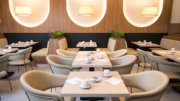 Un ristorante moderno con tavoli e sedie rotonde, illuminazione calda e rivestimenti in legno.