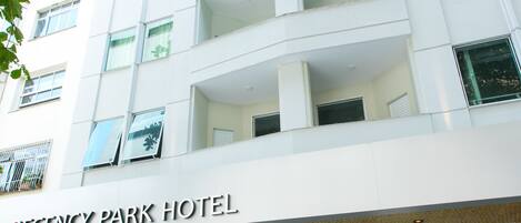 A multi-story hotel with a modern facade, large windows, and a sign reading "Regency Park Hotel".