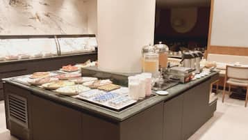 A buffet counter with various food items and beverages.