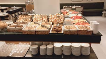 A buffet setup with various food items and utensils.