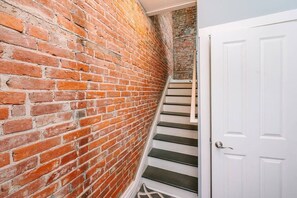 A brick wall, a white door, and a staircase.