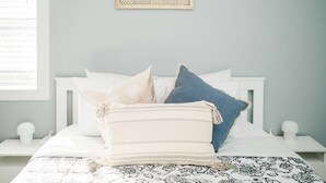 Ein Bett mit einer gemusterten Bettdecke, zwei Kissen und einer zusammengefalteten Decke.