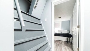 A staircase leading to a room with a bed, a chair, and a window. - -- AGH Walkable - Free Parking - Washer & Dryer -- (Pittsburgh)