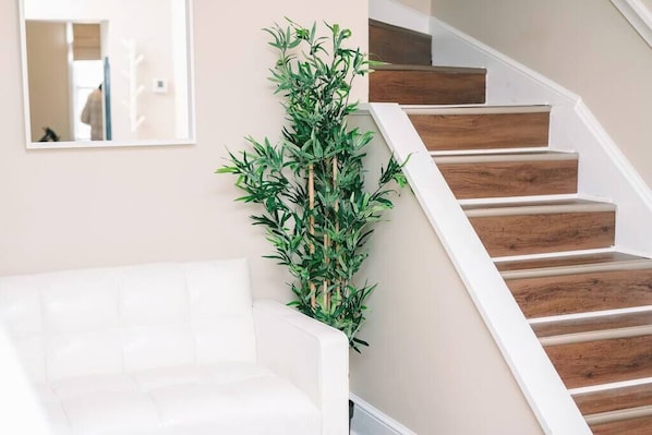 Una escalera con escalones de madera y una pared blanca.