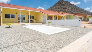A yellow building with a red roof, a gravel courtyard, and a mountain in the background. - NEW Casa Orcuyo in Santa Cruz (Santa Cruz)