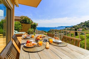 Enjoy a seaside breakfast on this deck with a dining table set amidst breathtaking views.