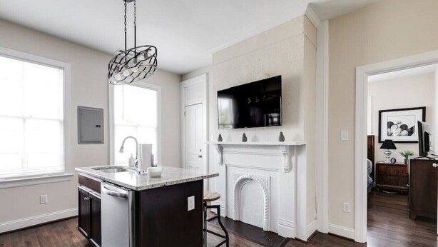 A kitchen with a central island, a fireplace, and a TV mounted above it. - Modern, Convenient Gem: Urban Retreat 'n Richmond (Richmond)