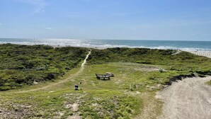 A coastal path leading to a beach with a bench and picnic table. - Beachgate Condo Suites And Hotel 231 1 Bedroom Condo (Port Aransas)