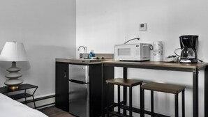 A compact kitchenette with a microwave, coffee maker, and refrigerator. - King Studio TC | Near Downtown + Near beach (Traverse City)