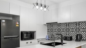 A modern kitchen with a stainless steel refrigerator, a microwave, a sink, and a coffee maker. - Unit 24-24 Hamilton Ave Surfers Paradise (Surfers Paradise)