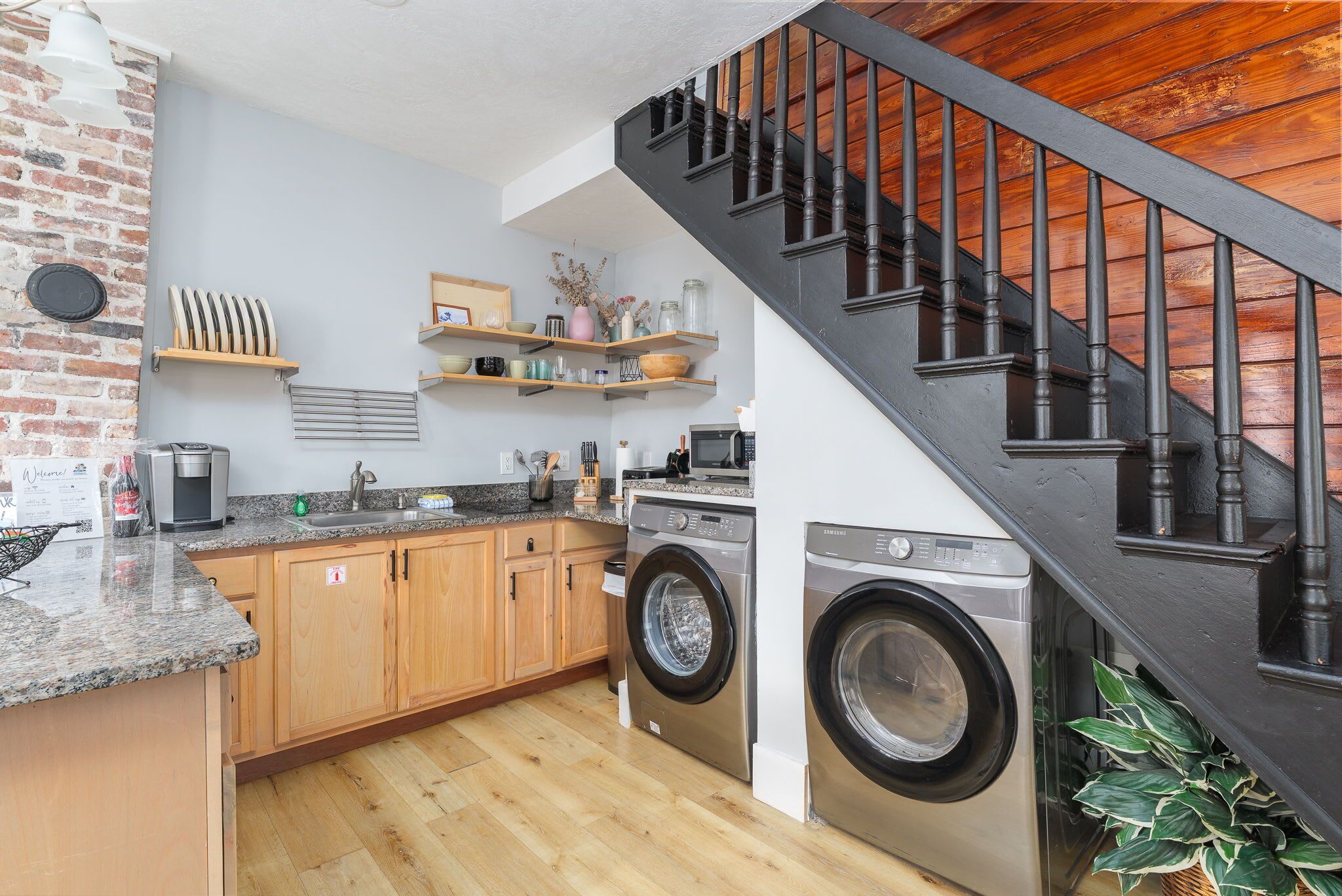 A modern kitchen with granite countertops, wooden cabinets, and stainless steel appliances.