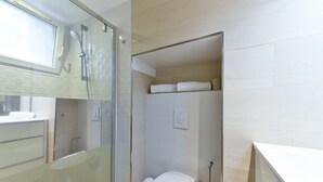Une salle de bain moderne avec une douche à parois de verre, des toilettes et un espace lavabo.
