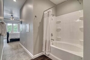 Bathtub, hair dryer, towels, shampoo