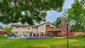 A two-story house with a covered porch and a small outdoor seating area. - Backyard Oasis Pool | Beautiful Home (Arvada)