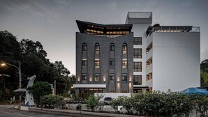 Un bâtiment moderne doté d’une architecture remarquable, notamment au niveau de ses angles, de nombreuses fenêtres et d’un toit plat.